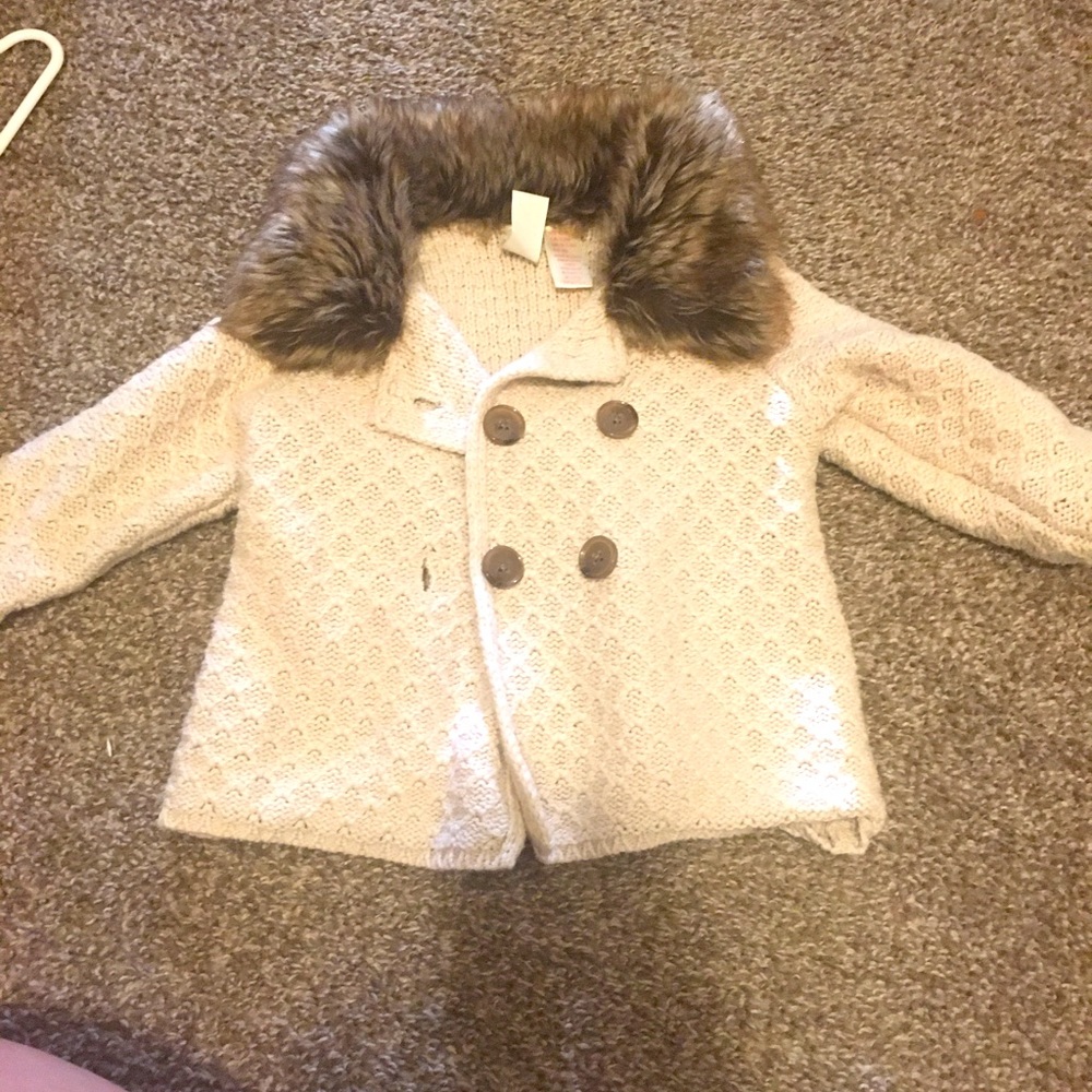 Cream colored baby sweater with faux fur trim
